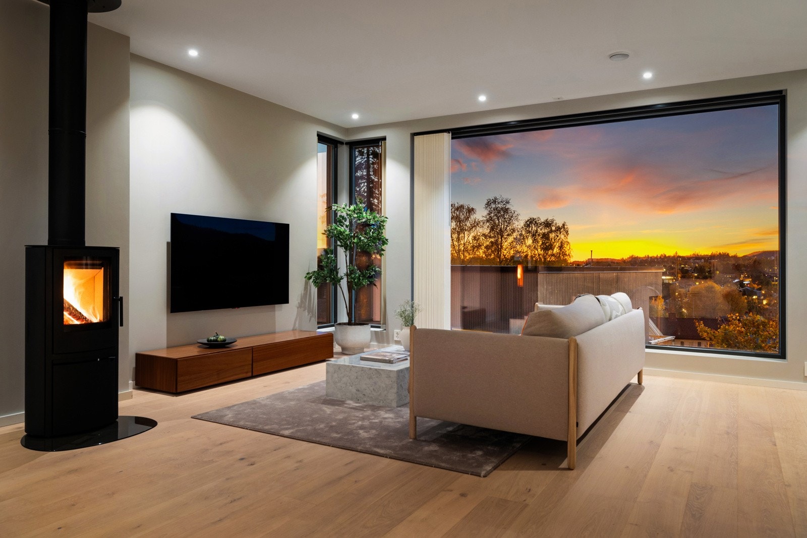 Midt i rommet står en elegant peisovn som bidrar til både varme og hygge på kjølige kvelder. Galleribilde