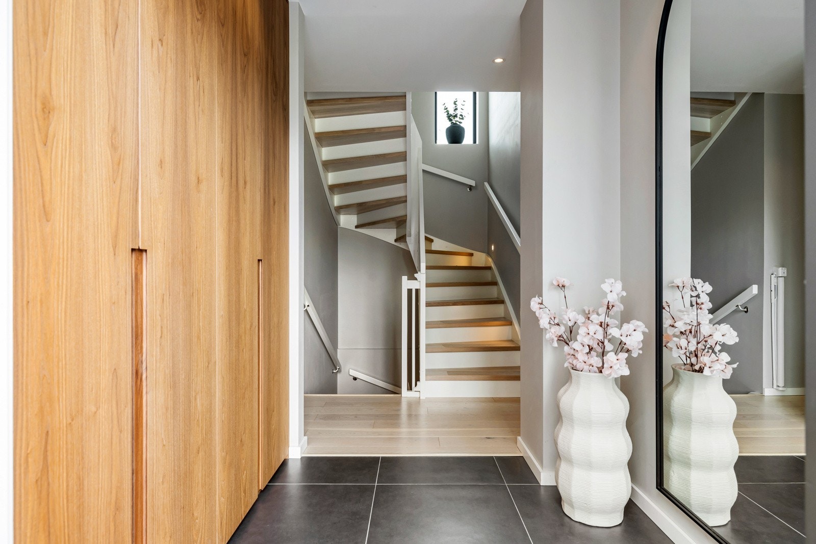 Fra entréen leder en pen trapp med heltre trinn og integrert trappebelysning videre oppover i boligen. Galleribilde