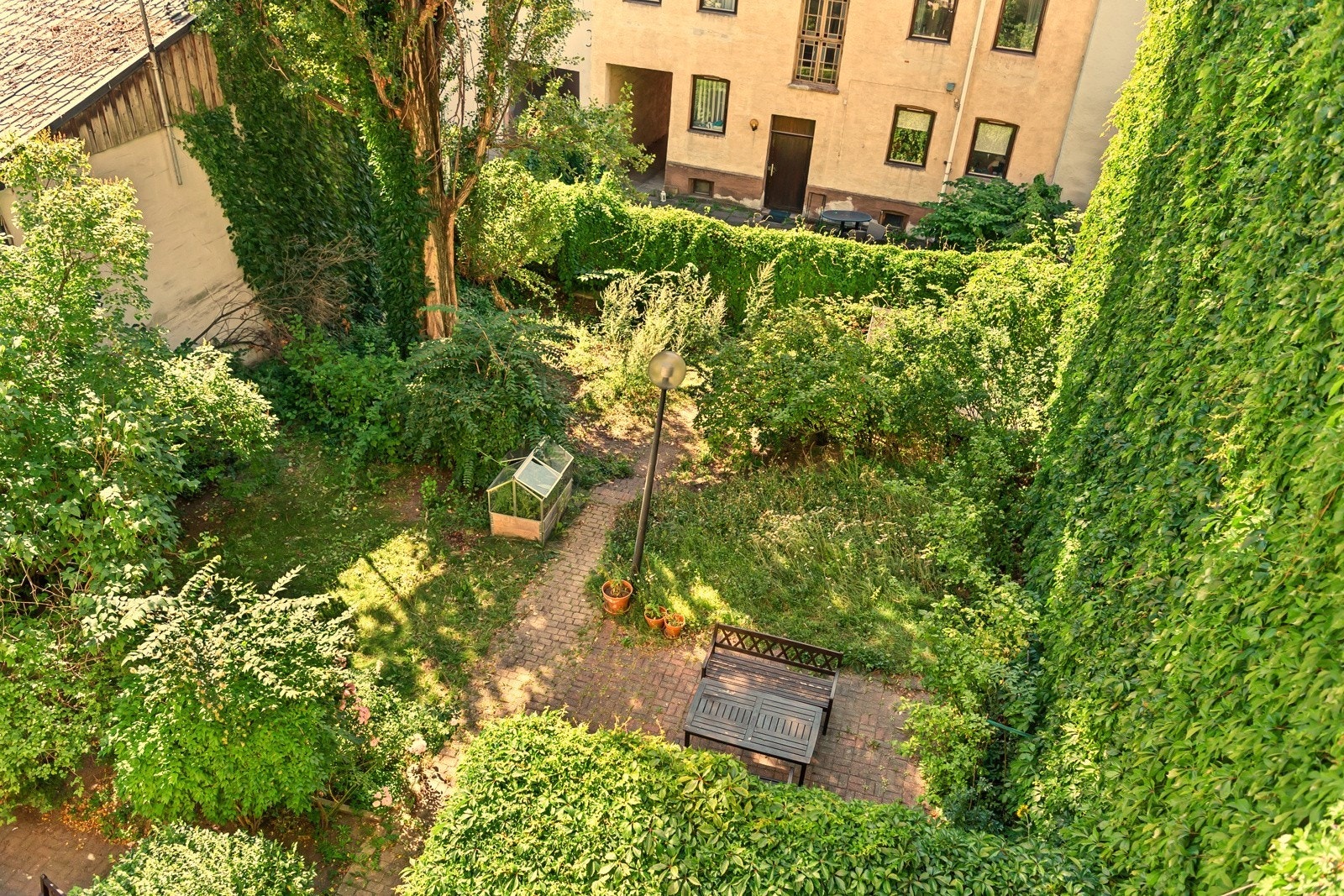 Sommerbilde av bakgården. Borettslaget oppleves virkelig som en grønn oase til tross for den sentrale beliggenheten! Galleribilde