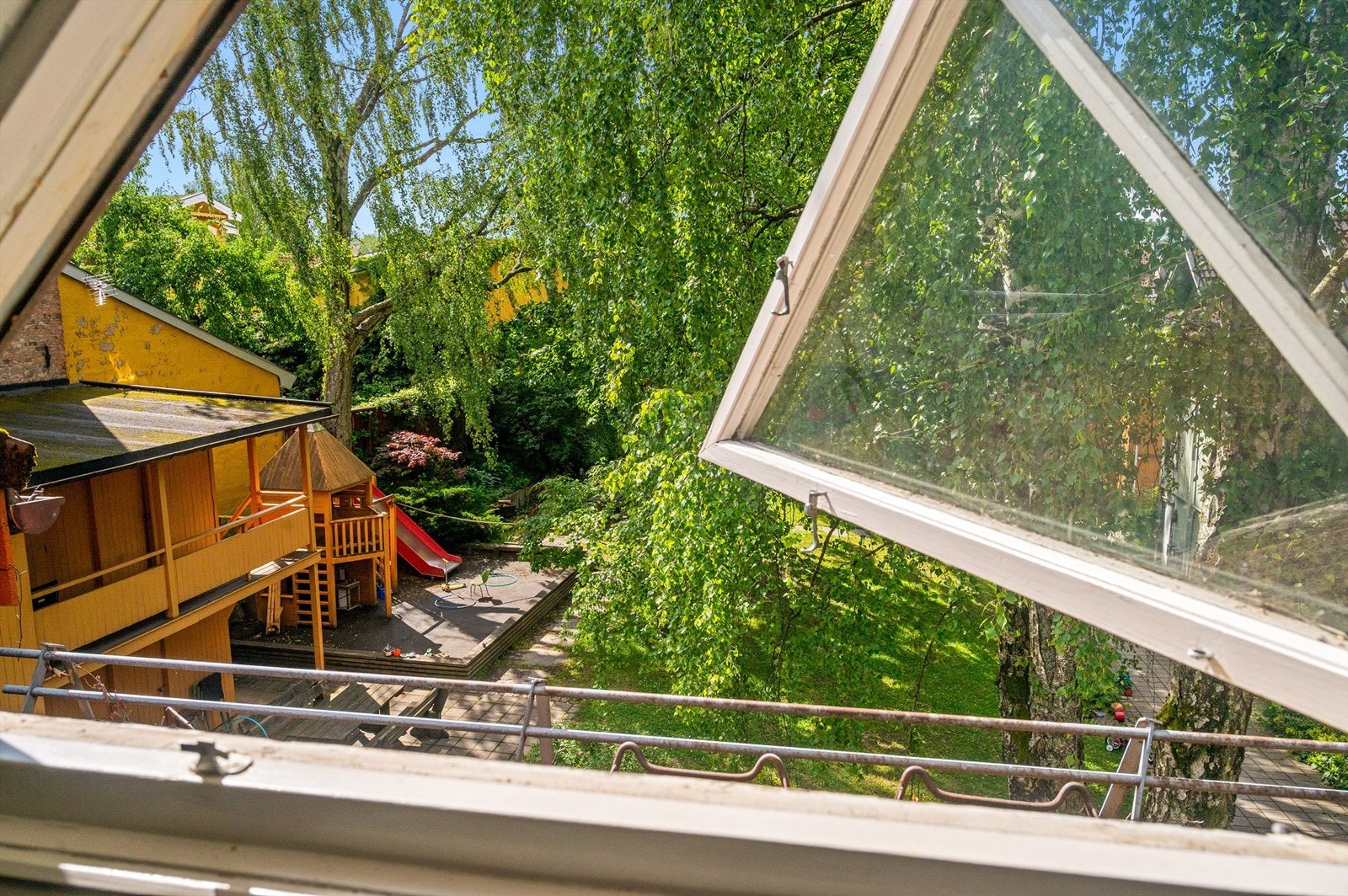 Utsikt fra vinduet mot det grønne og frodige fellesområdet. Galleribilde