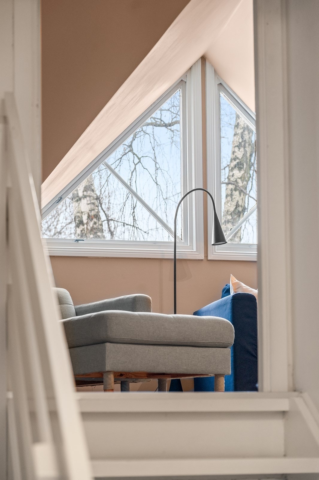 Under sjarmerende trekantvinduer, finner du boligens loftstue som i dag benyttes som tv-stue. Galleribilde