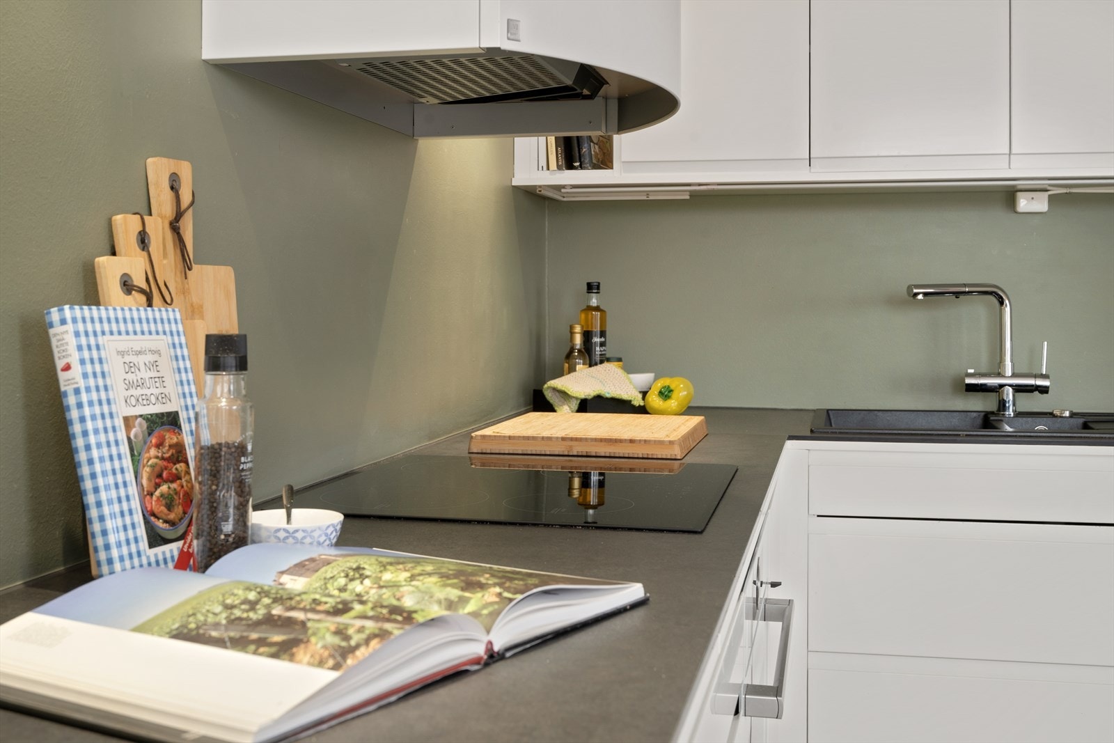 Smal og trendy benkeplate som gir en solid arbeidsflate med induksjonstoppen sentralt plassert. Galleribilde