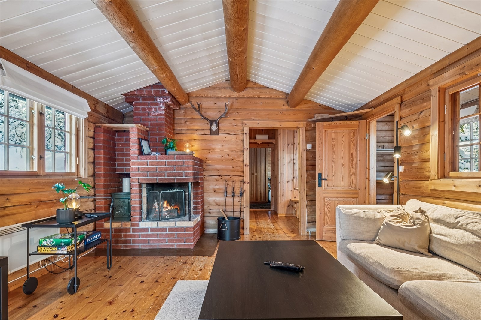 Et tradisjonelt ildsted fra byggeåret med en vedovn inntil peisen. Galleribilde