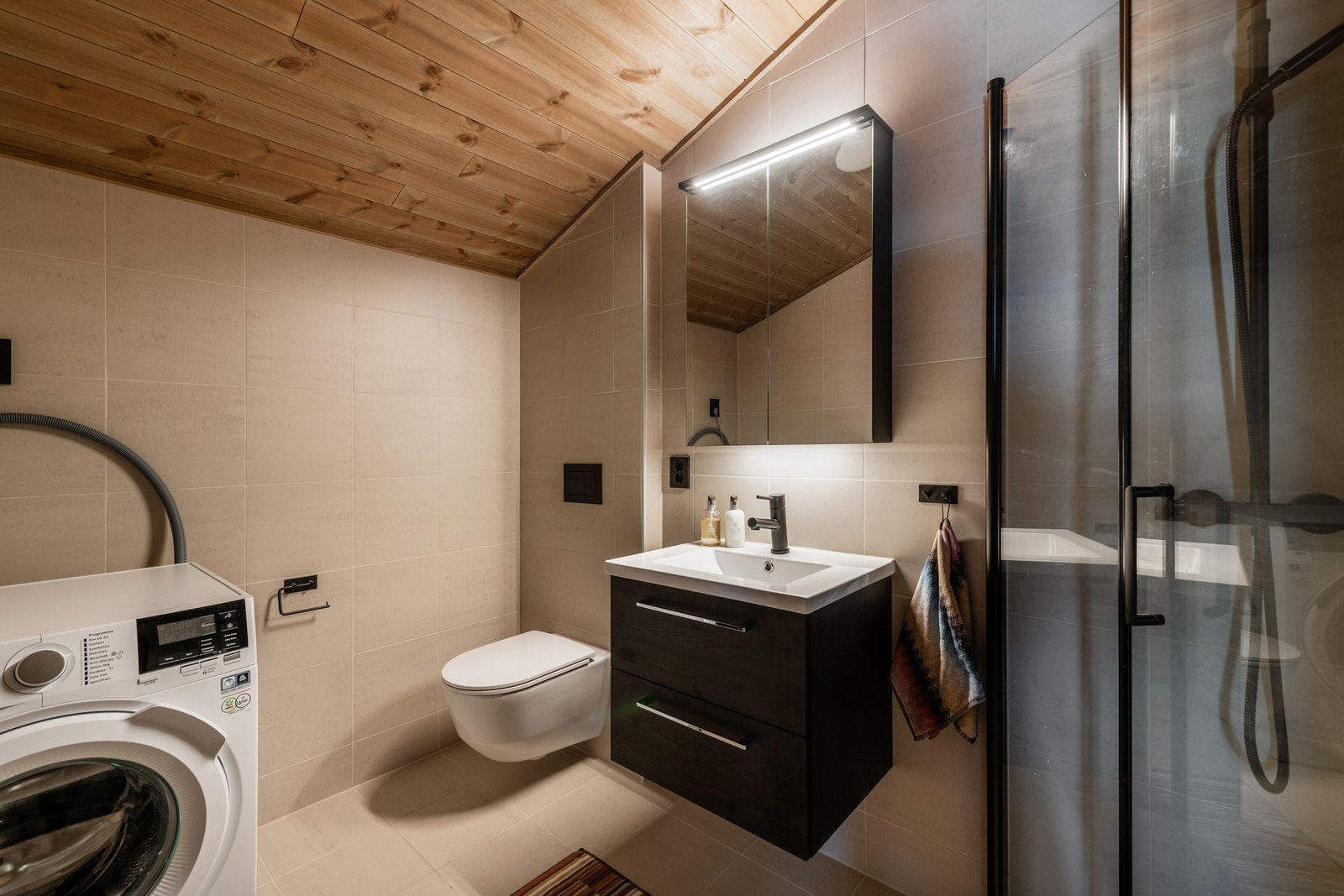 Badet har opplegg for vaskemaskin, toalett, servantinnredning og hjørnedusj Galleribilde