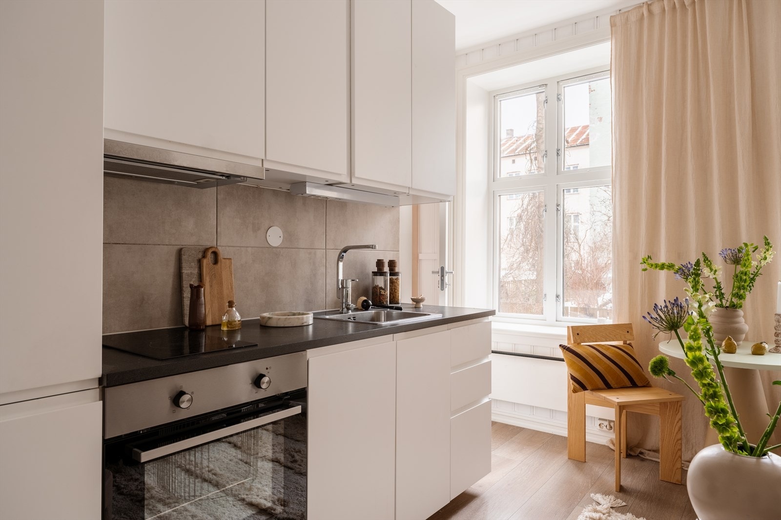 Tidsriktig og stilren glatt innredning, soft close, fliser over benk, armatur, laminat benkeplate med nedfelt stålkum og keramisk topp. Galleribilde