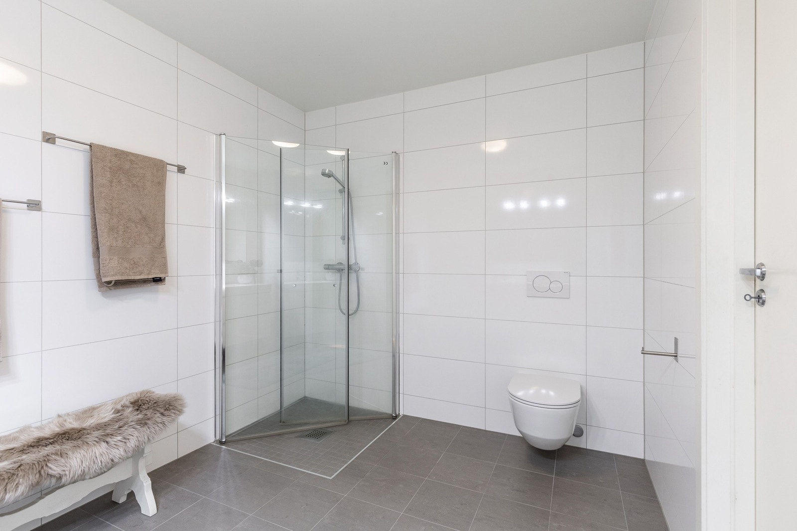 Badet ligger i første etasje og er flislagt med stilrene hvite og grå fliser, samt varmekabler i gulv. Galleribilde