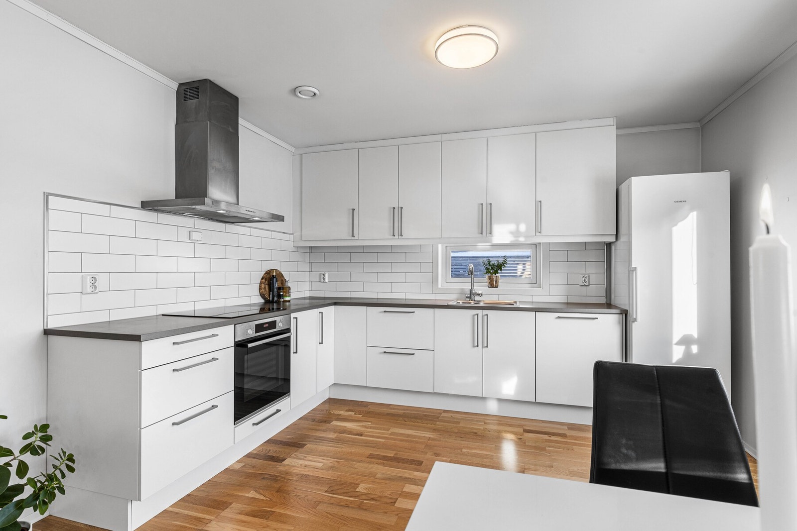 Kjøkkeninnredningen fra Sigdal (2018) har glatte, hvite fronter og laminert benkeplate med nedfelt utslagsvask. Galleribilde