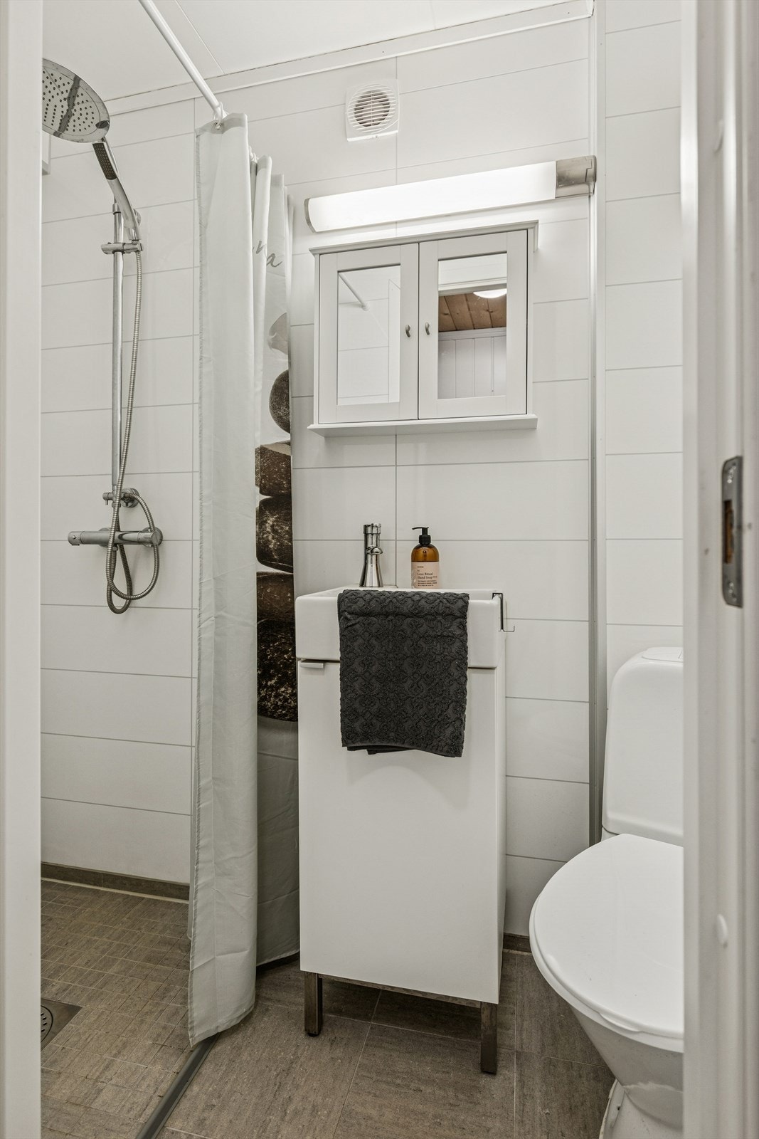 Praktisk baderom (2013) med dusjløsning og funksjonell innredning Galleribilde