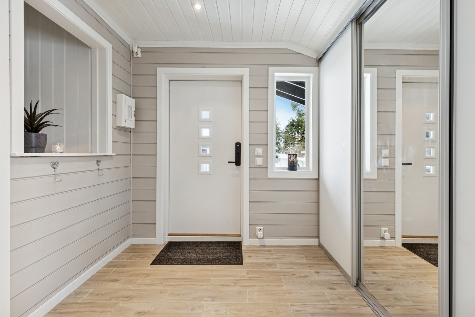 Boligen ønsker deg velkommen inn med et hyggelig inngangsparti med dobbel skyvedørsgarderobe og spotter i taket. Galleribilde