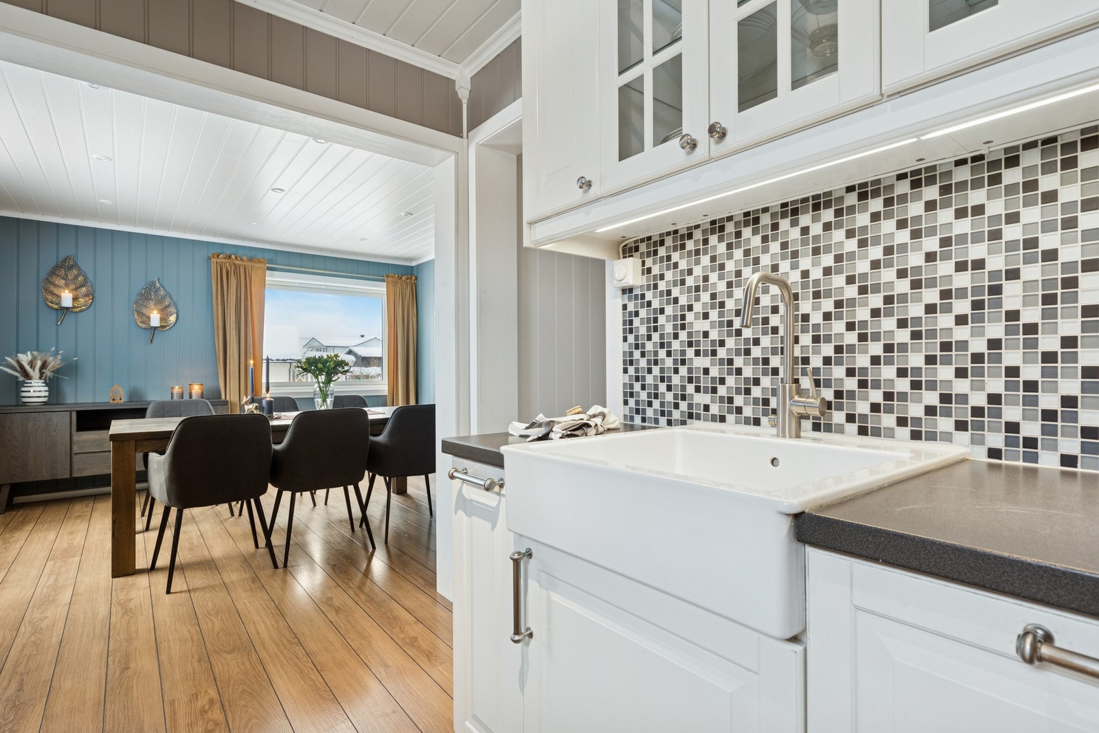 Kjøkkenet er utstyrt med mosaikkflise mellom benkeplate og overskap. Galleribilde