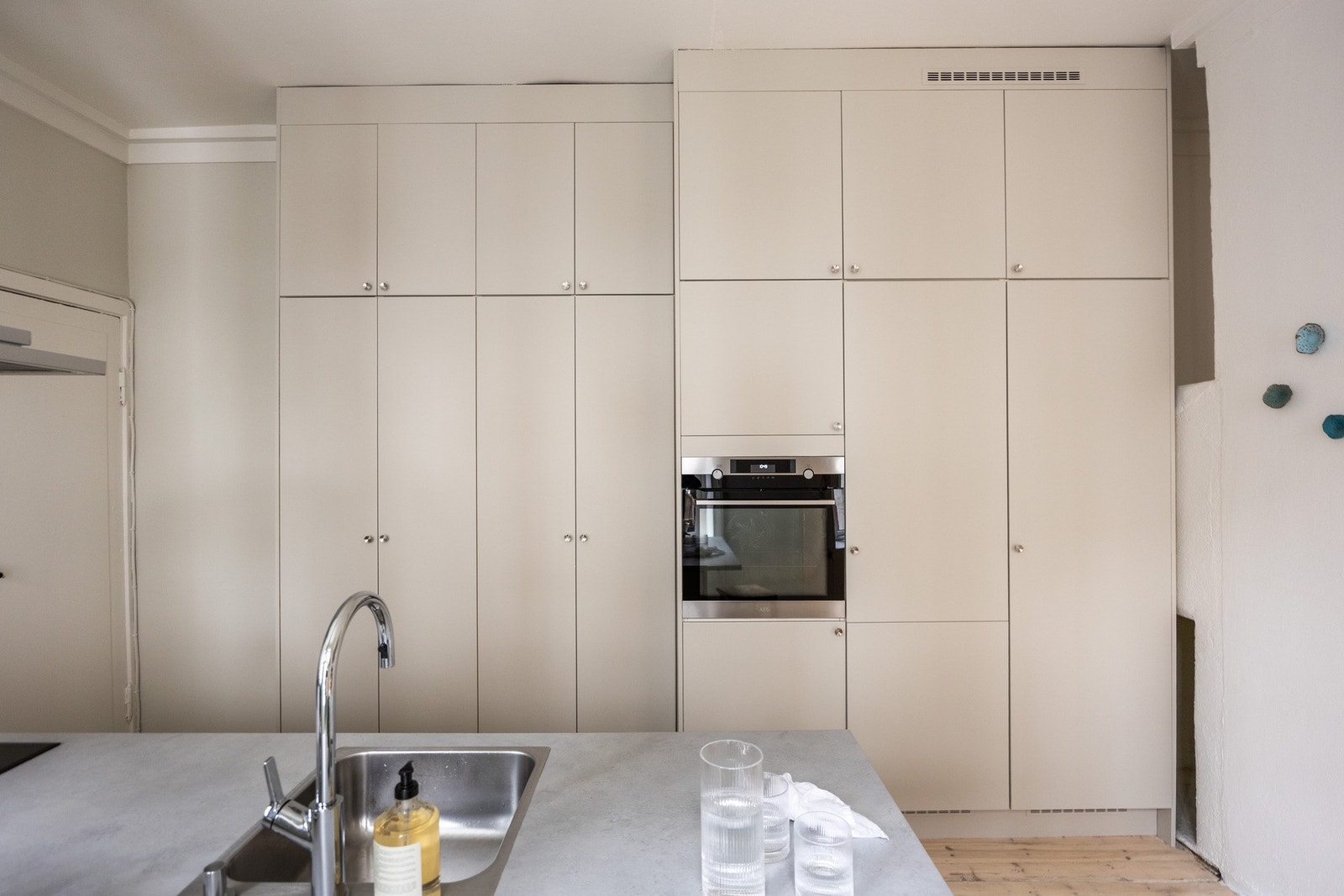 Kjøkkenet fremstår lekkert med slette, lyse fronter. Galleribilde