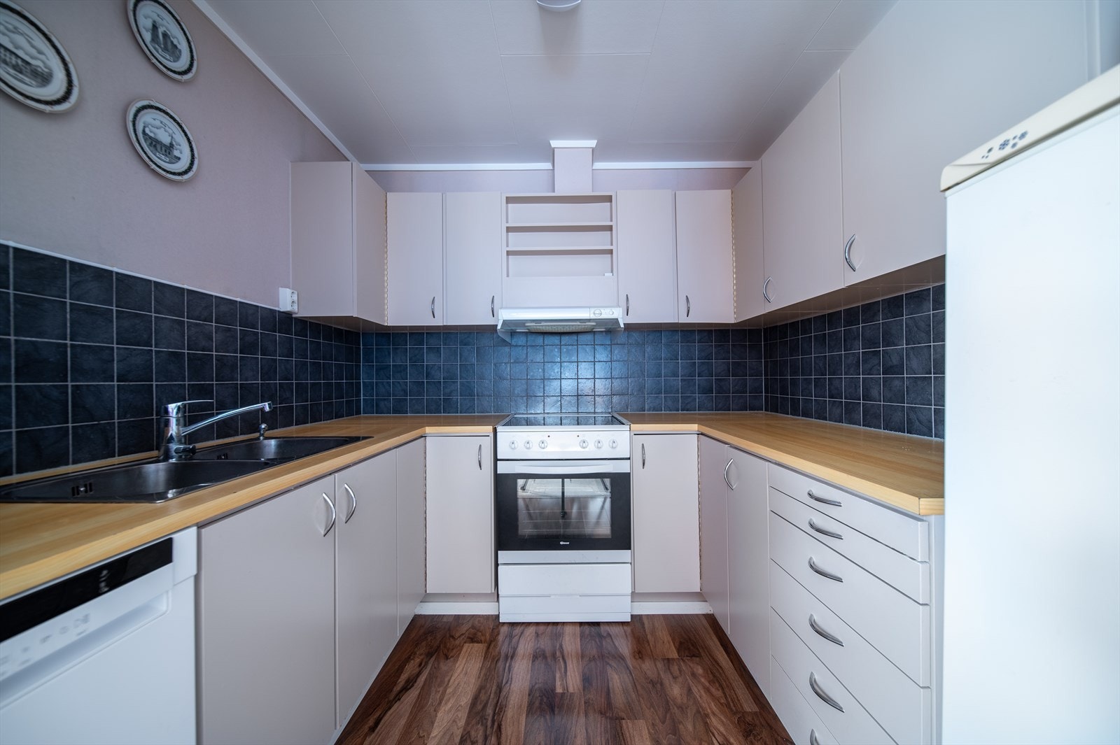 Kjøkken med slette fronter og laminat benkeplate Galleribilde