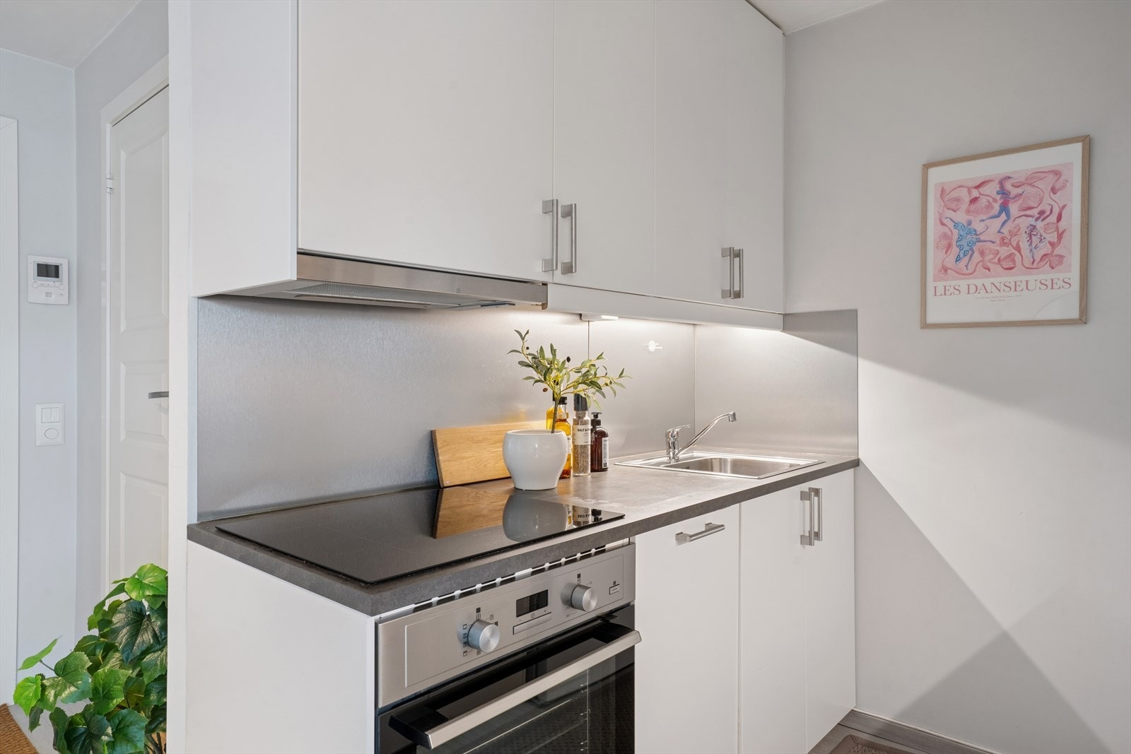 Over benken er det montert en stålplate, og det er LED-lys under overskapene. Galleribilde