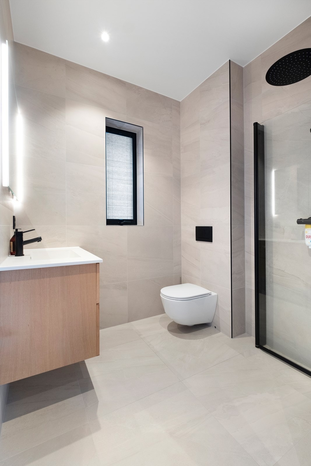 Vegghengt toalett og servant med god oppbevaringsplass gir et ryddig bad. Galleribilde