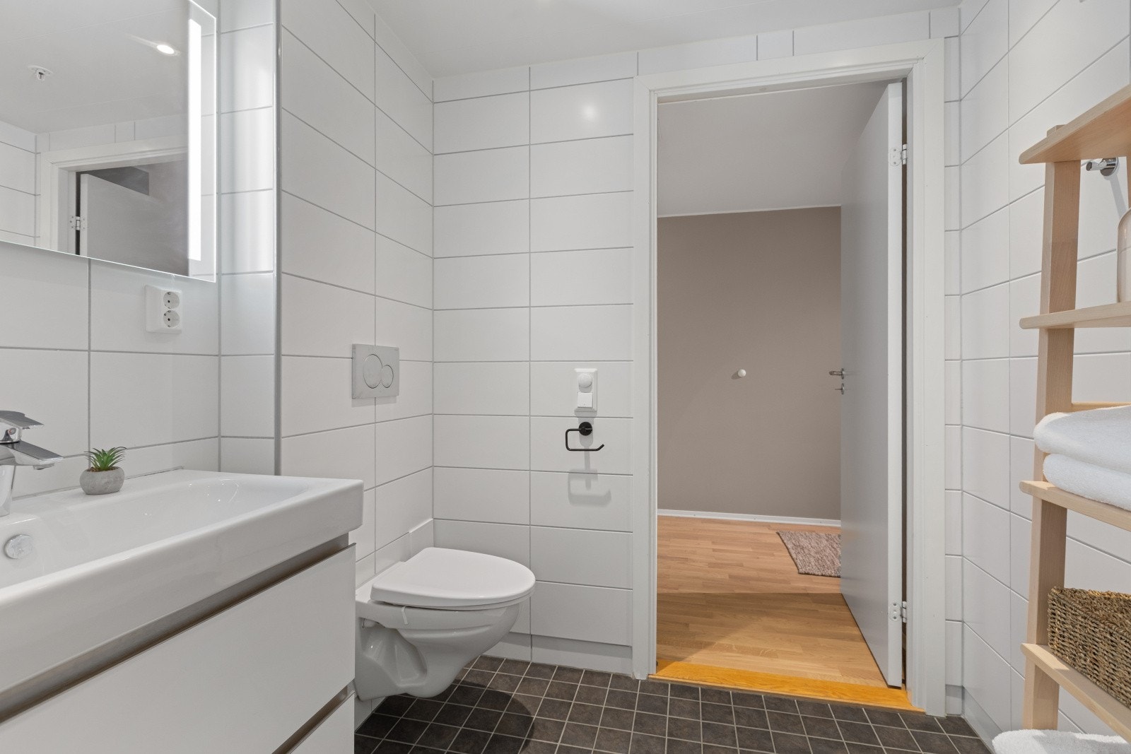 Her finner du servant, veggmontert toalett og dusjhjørne med to svingbare glassdører. Galleribilde