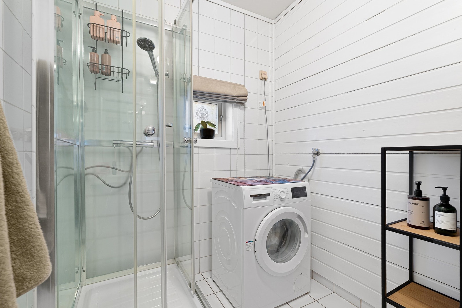 Rommet har opplegg for vaskemaskin. her er det blitt dusjet i kabinett for å forlenge badets levetid. Galleribilde