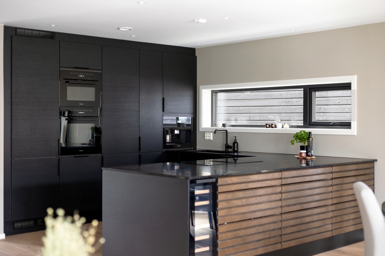 Kjøkkenet er innredet med en stilren og funksjonell Sigdal-løsning med heltre og finérte eikefronter, som gir et varmt og tidløst uttrykk. Galleribilde