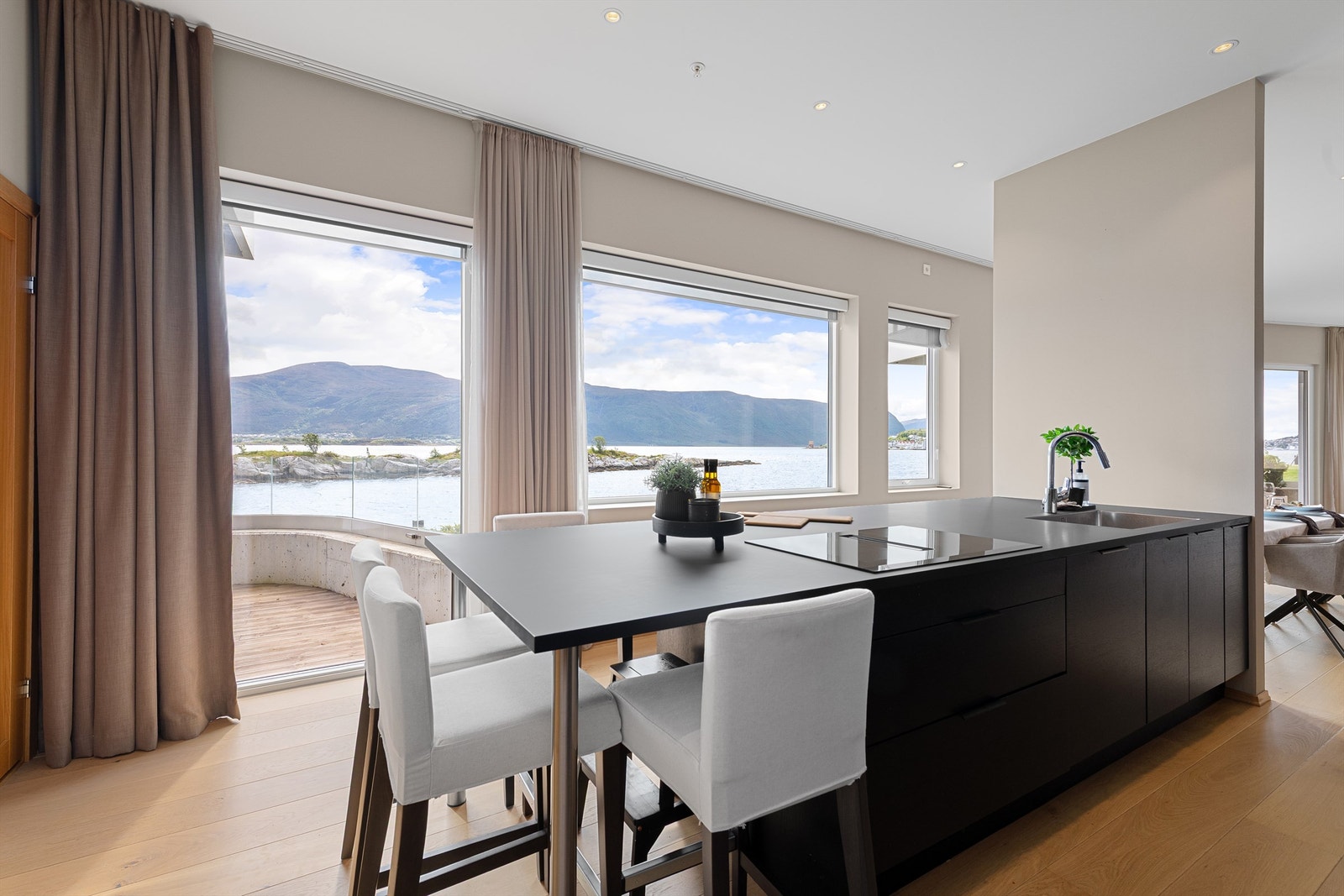 Kjøkkenet har fine sitteplasser rundt kjøkkenøyen,
som innbyr til å ta morgenkaffen og til sosialt samvær
rundt matlaging. Også her kan man nyte den magiske
utsikten Galleribilde