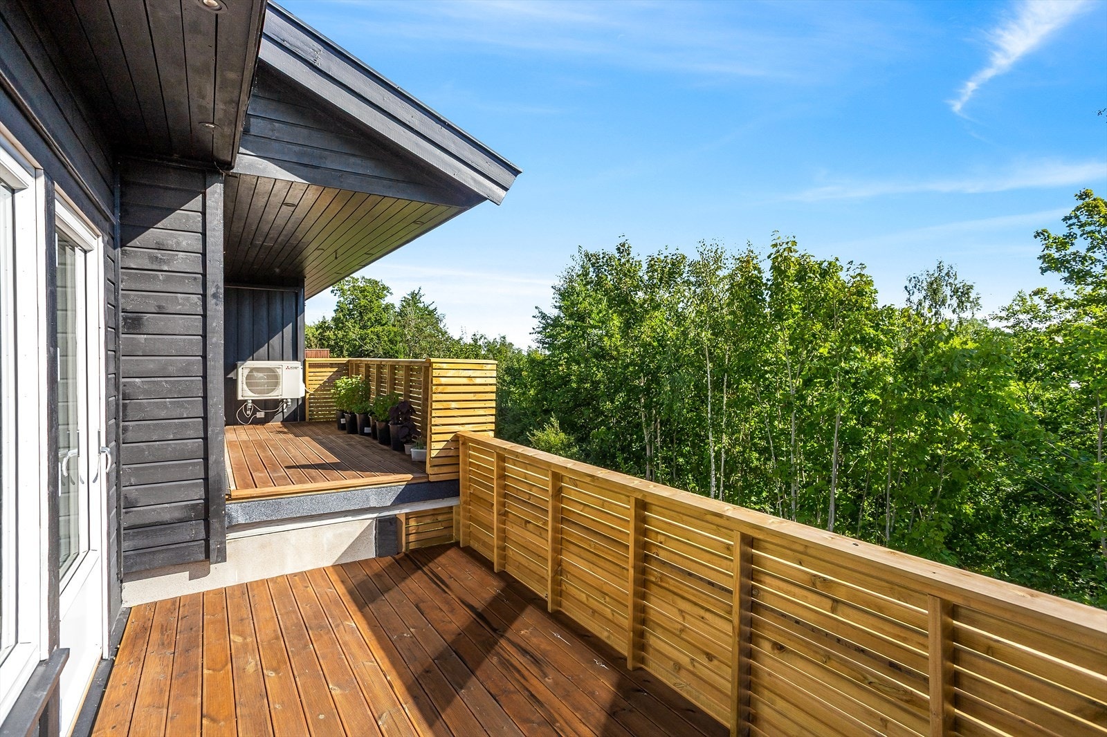 Stor, solrik terrasse med fri utsikt over grønne omgivelser. Galleribilde