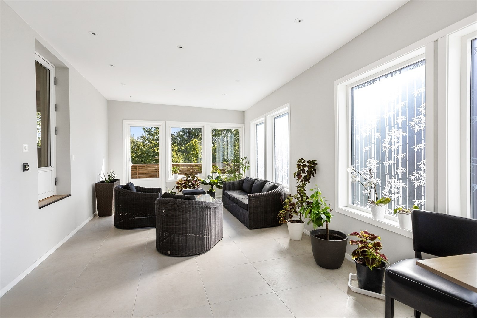 Store gulvfliser, downlights og store vindusflater mot frodige omgivelser. Galleribilde