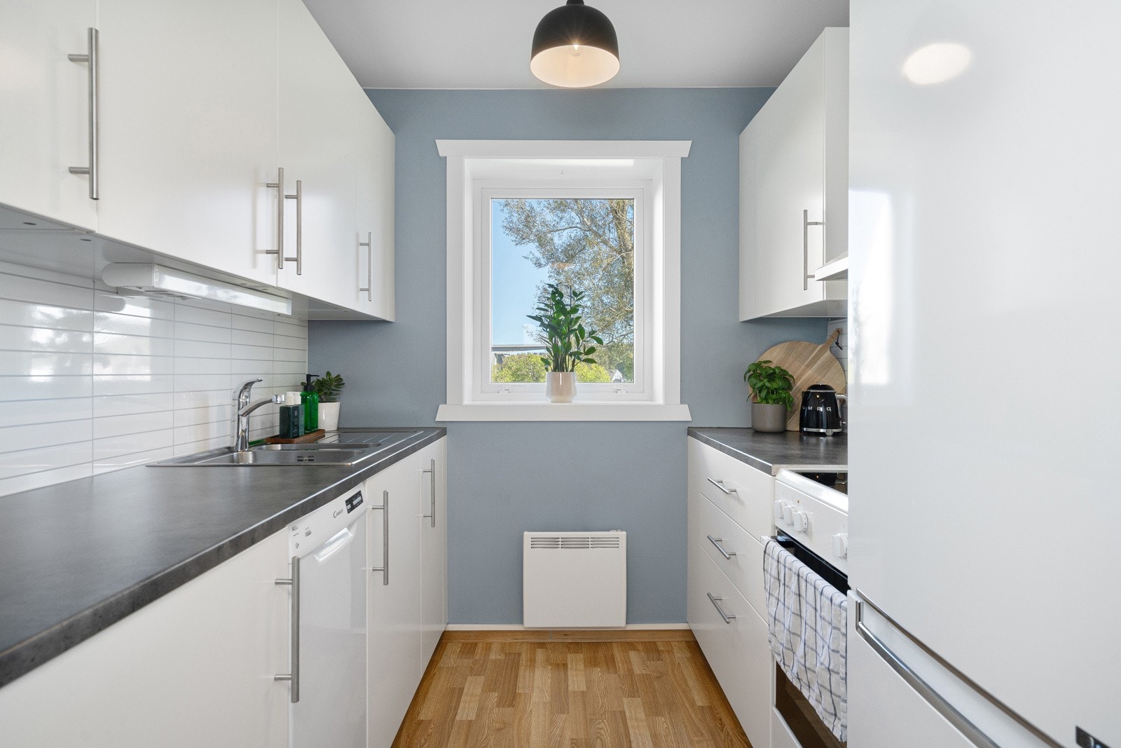 Kjøkkenet er moderne med slette fronter. Legg merke til at det er vindu på kjøkkenet! Fint lys slippes inn og det er utsikt ut mot fellesområdene. Galleribilde