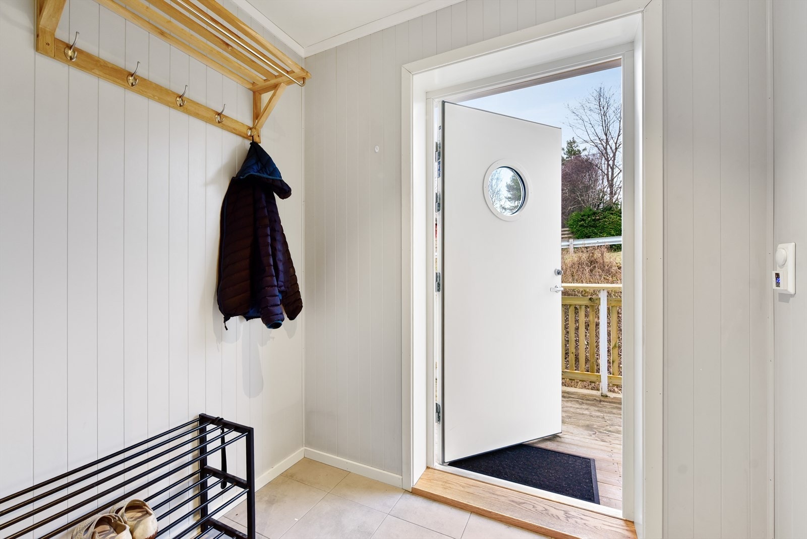 Innbydende entré med flislagt gulv og plass til oppbevaring av yttertøy. Galleribilde