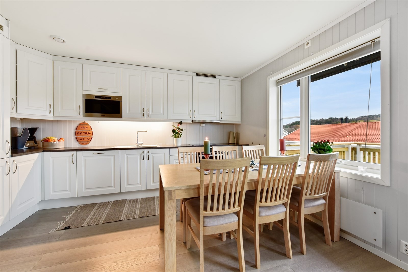 Kjøkkeninnredning med profilerte fronter, laminat benkeplate og god plass til spisebord. Alle hvitevarer er integrerte. Her finnes stekeovn, mikro, platetopp, oppvaskmaskin og kjøl-/fryseskap. Galleribilde