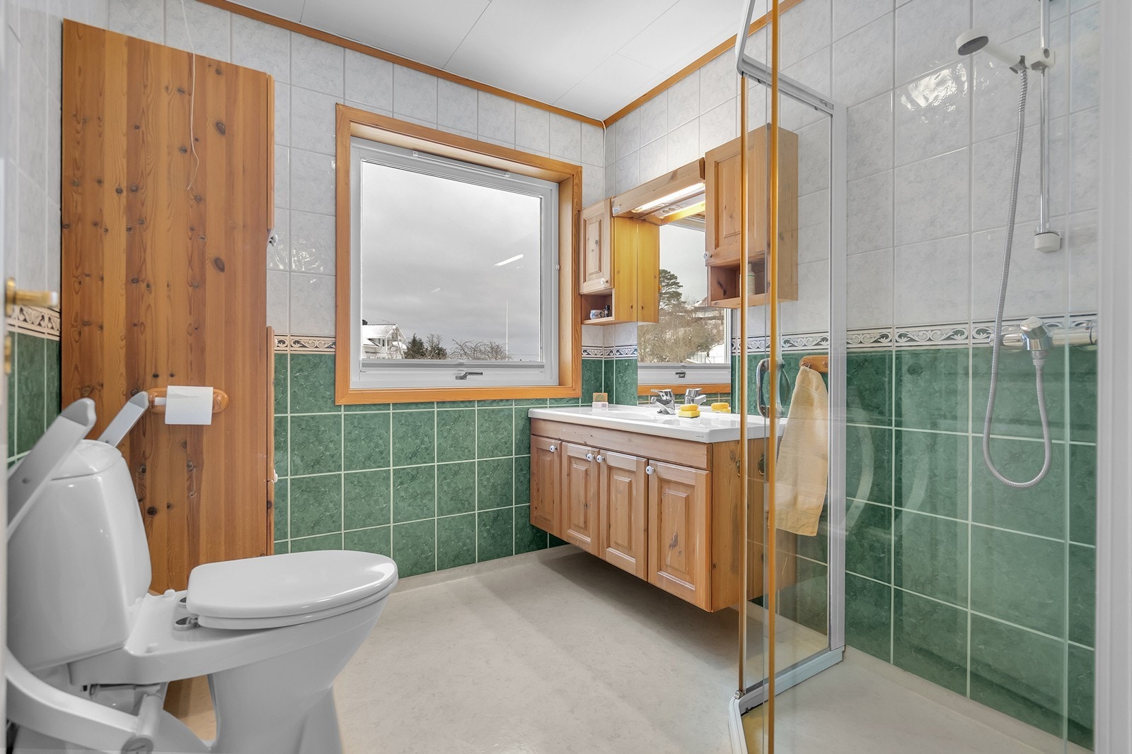 Bad med dusjhjørne, servant og vindu som gir naturlig lys. Galleribilde