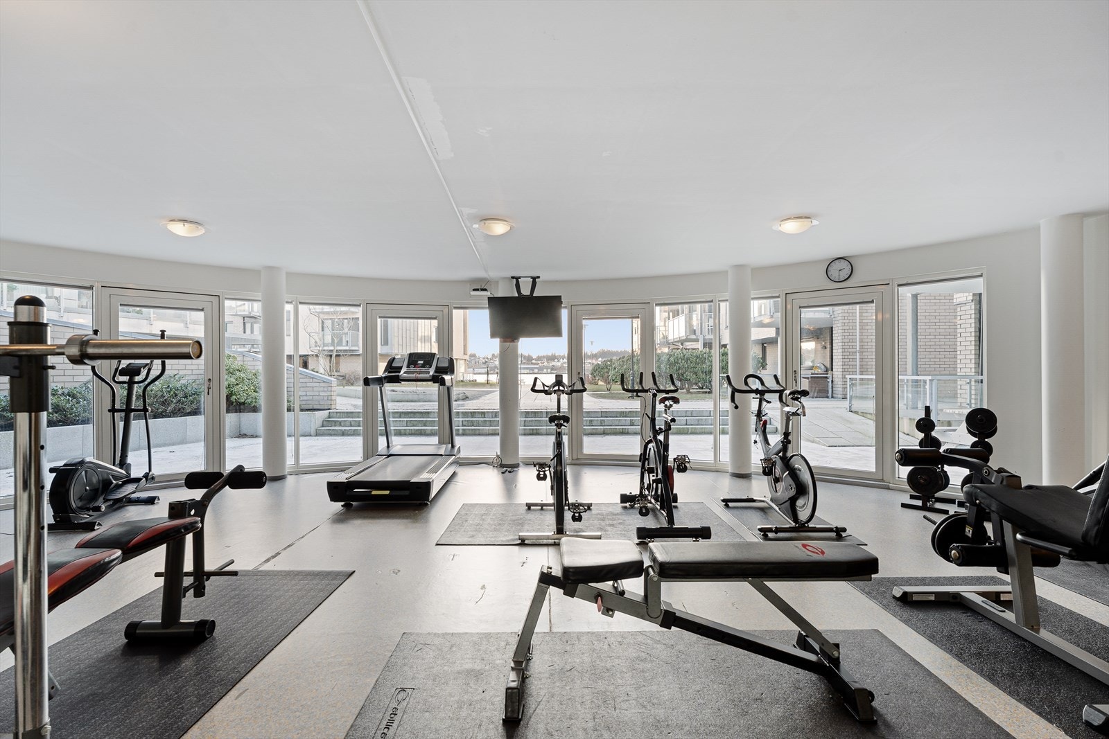 Felles treningsrom med en rekke apparater og med utsikt til sjøen Galleribilde