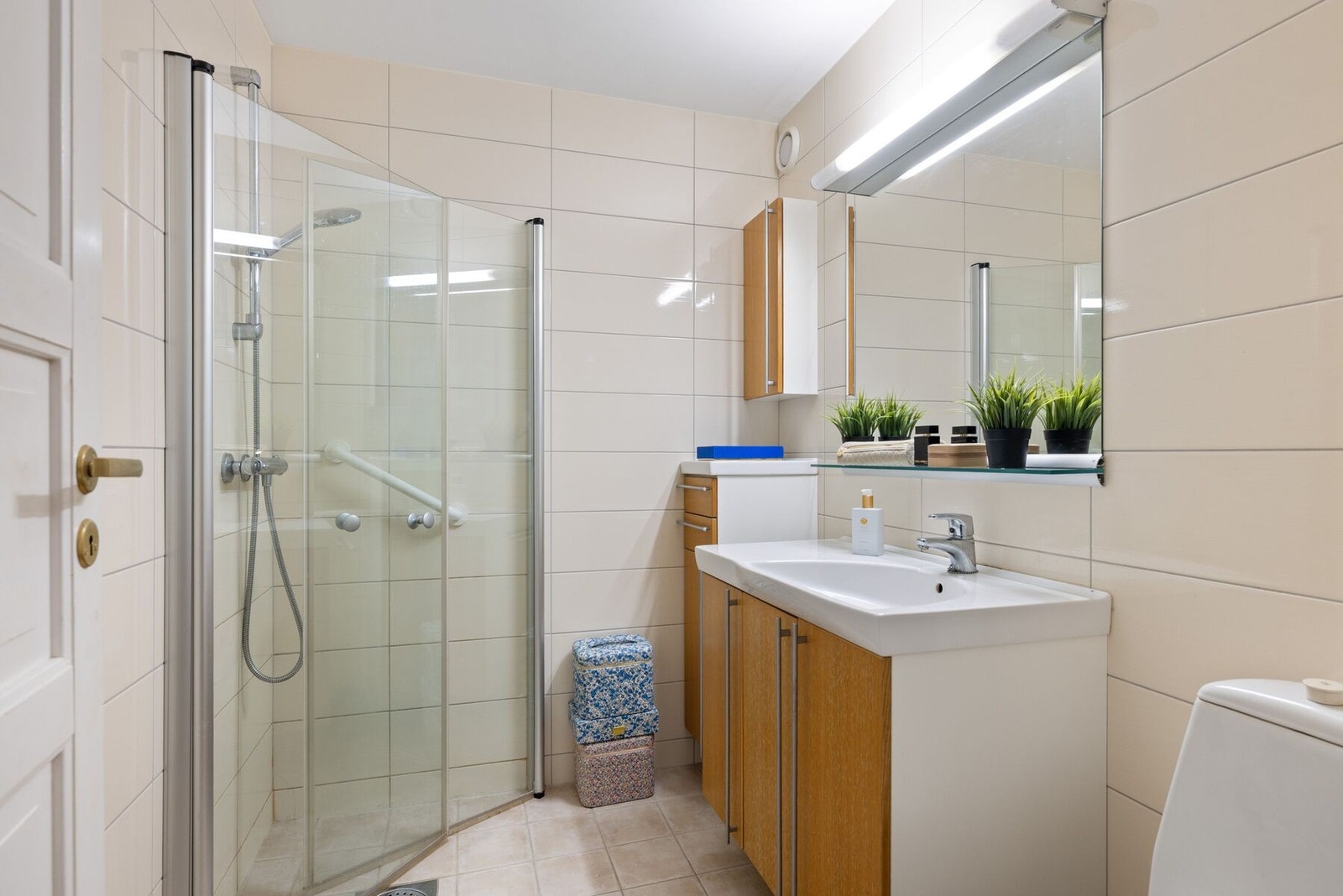 Bad nr. to har flislagte overflater og baderomsinnredning med god skapplass Galleribilde