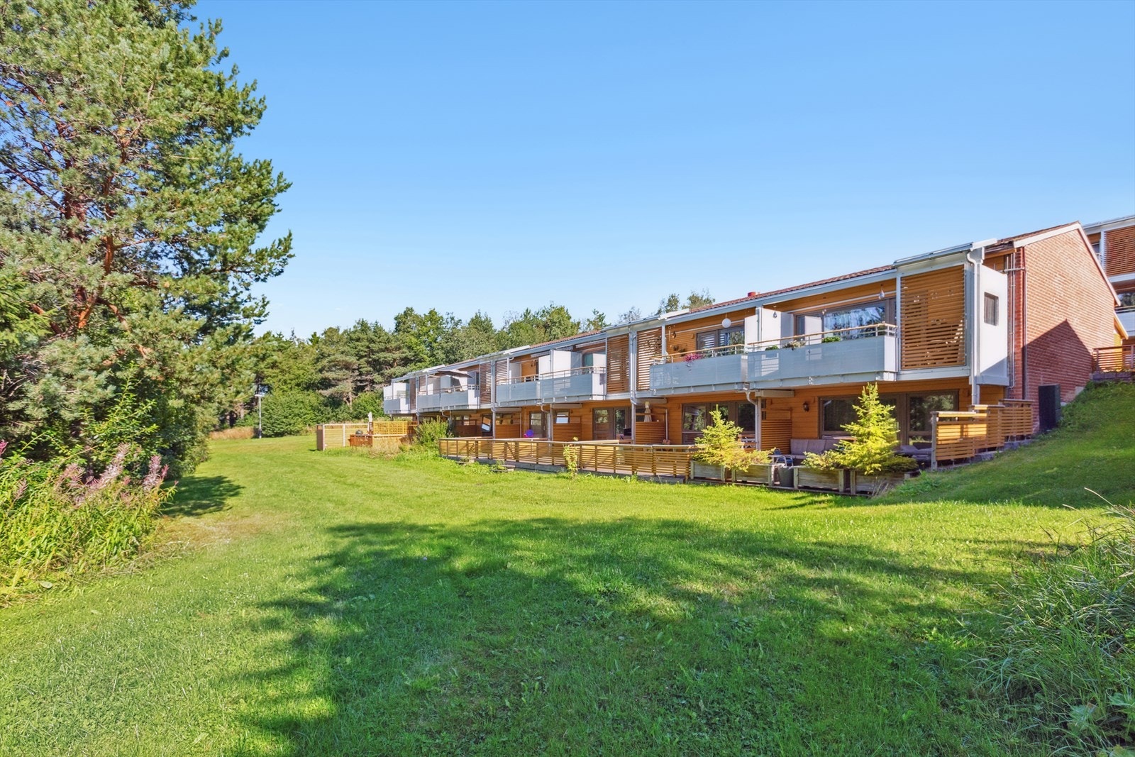 Felleseid tomt for borettslaget. Pent opparbeidet og utlagt med plen, busker og trær. Galleribilde