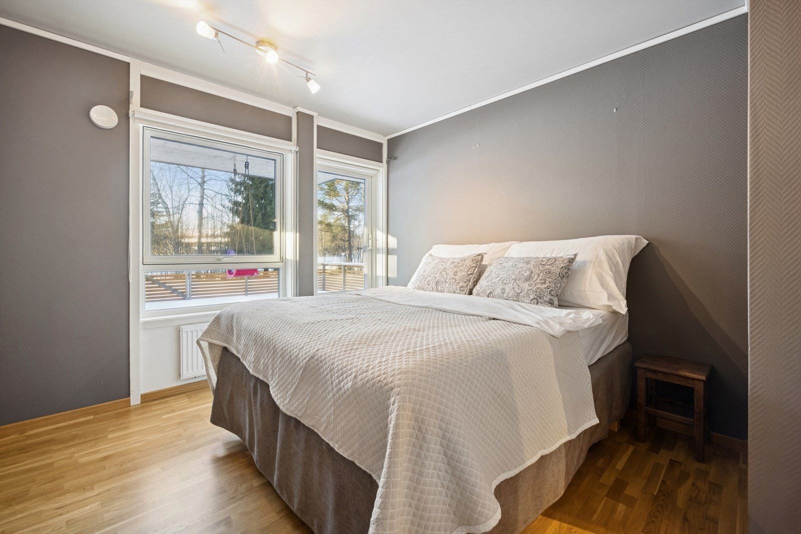 Meget pent soverom på 16,6 m² malt i en dus og tidsriktig farge. Her har du direkte utgang til en av boligens terrasser. Galleribilde