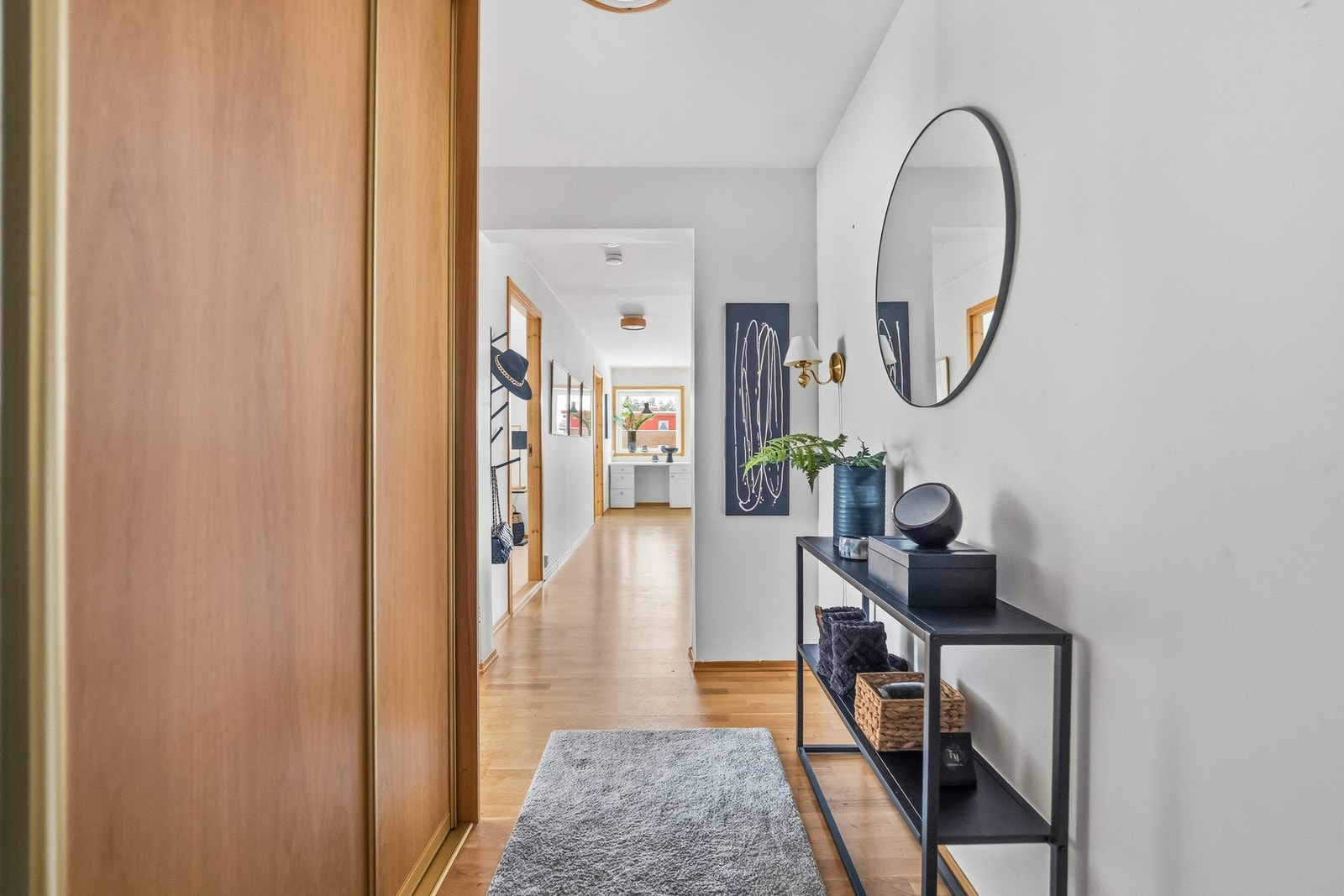 Romslig og lys entré med god plass til oppbevaring. Entréen kan skilte med en stor skyvedørsgarderobe, som gir praktisk og effektiv oppbevaring av yttertøy og sko. Galleribilde