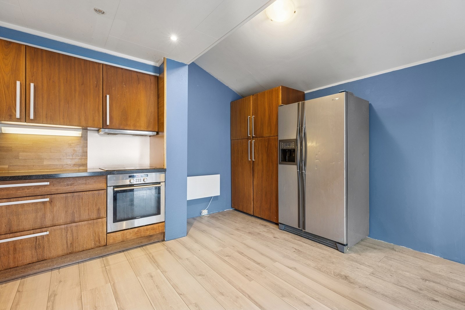 De integrerte hvitevarene, som inkluderer ovn, platetopp og oppvaskmaskin, gjør kjøkkenet både funksjonelt og praktisk. Galleribilde