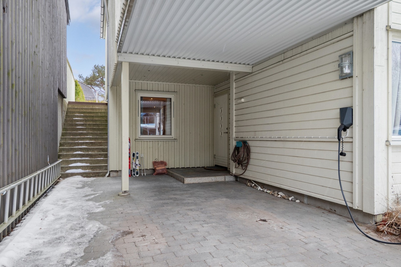 Parkering i carport med elbil lader rett utenfor inngangsdøren. Galleribilde