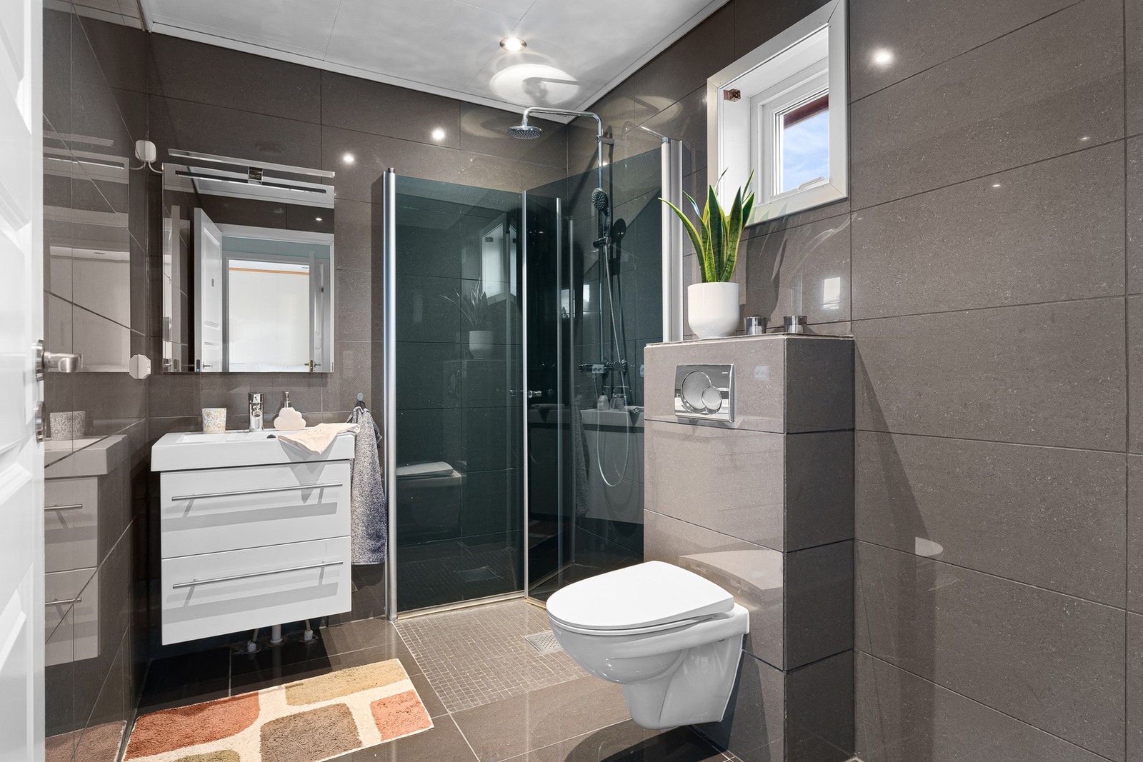 Leiligheten har et bad med flislagt gulv og vegger. Galleribilde