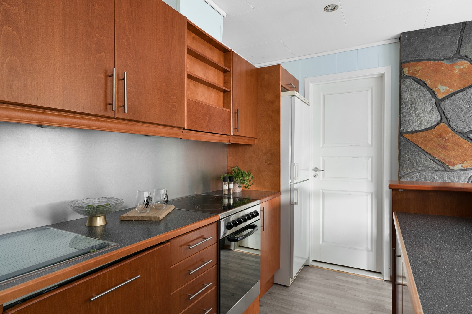 Kjøkkenet er utstyrt med frittstående komfyr og kjøleskap. Galleribilde