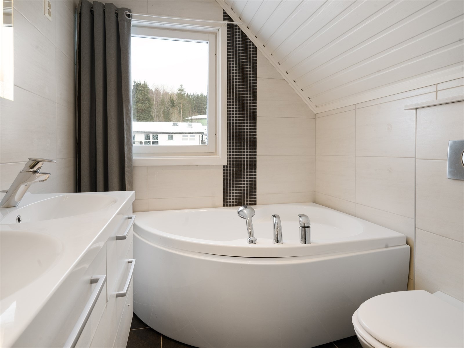 Rommet er innredet med et servantskap med to servanter og et badekar/boblebad. Galleribilde