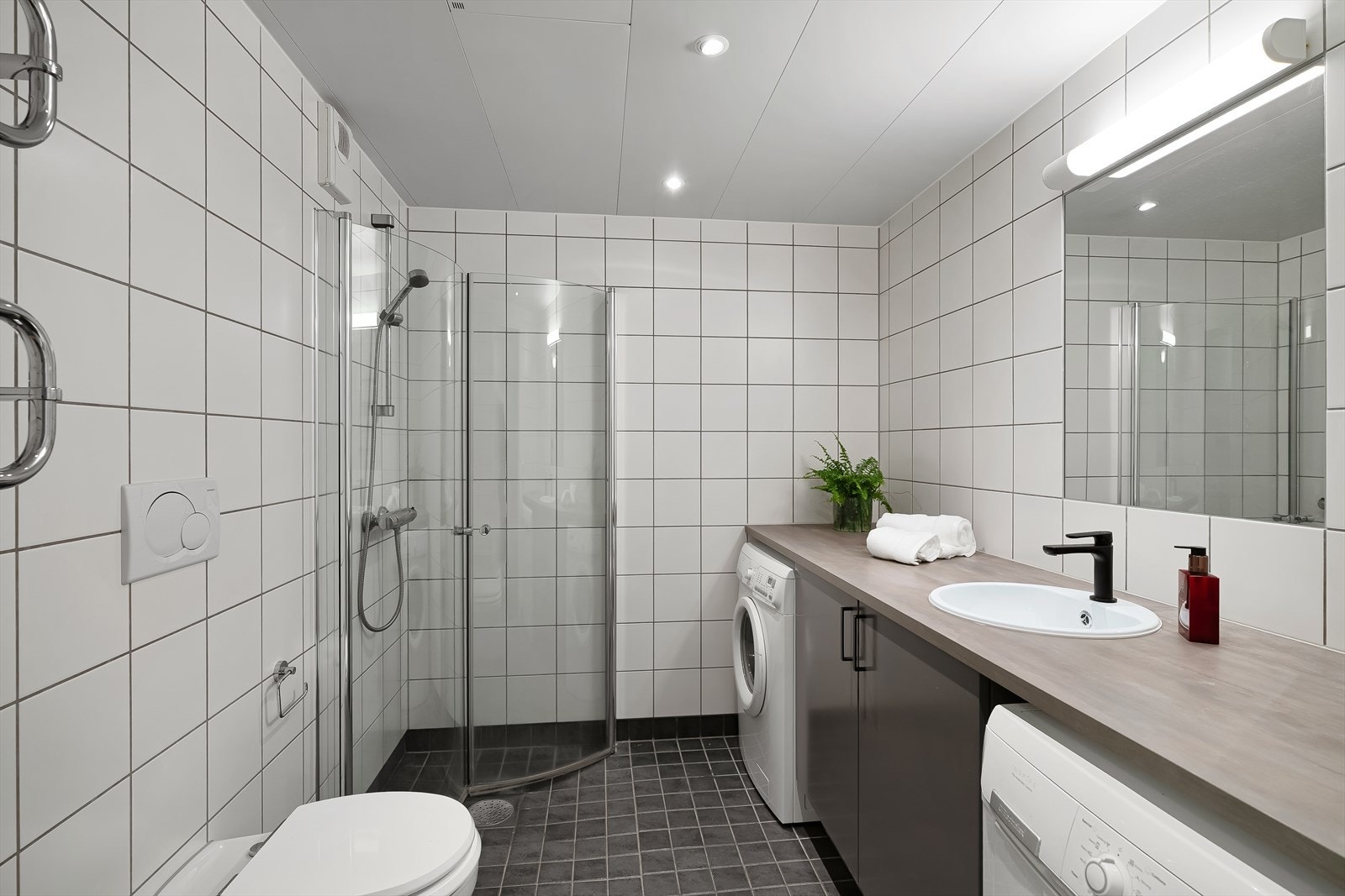 Pent flislagt bad med gulvvarme, downlights og dusjhjørne med innfellbare dusjdører Galleribilde