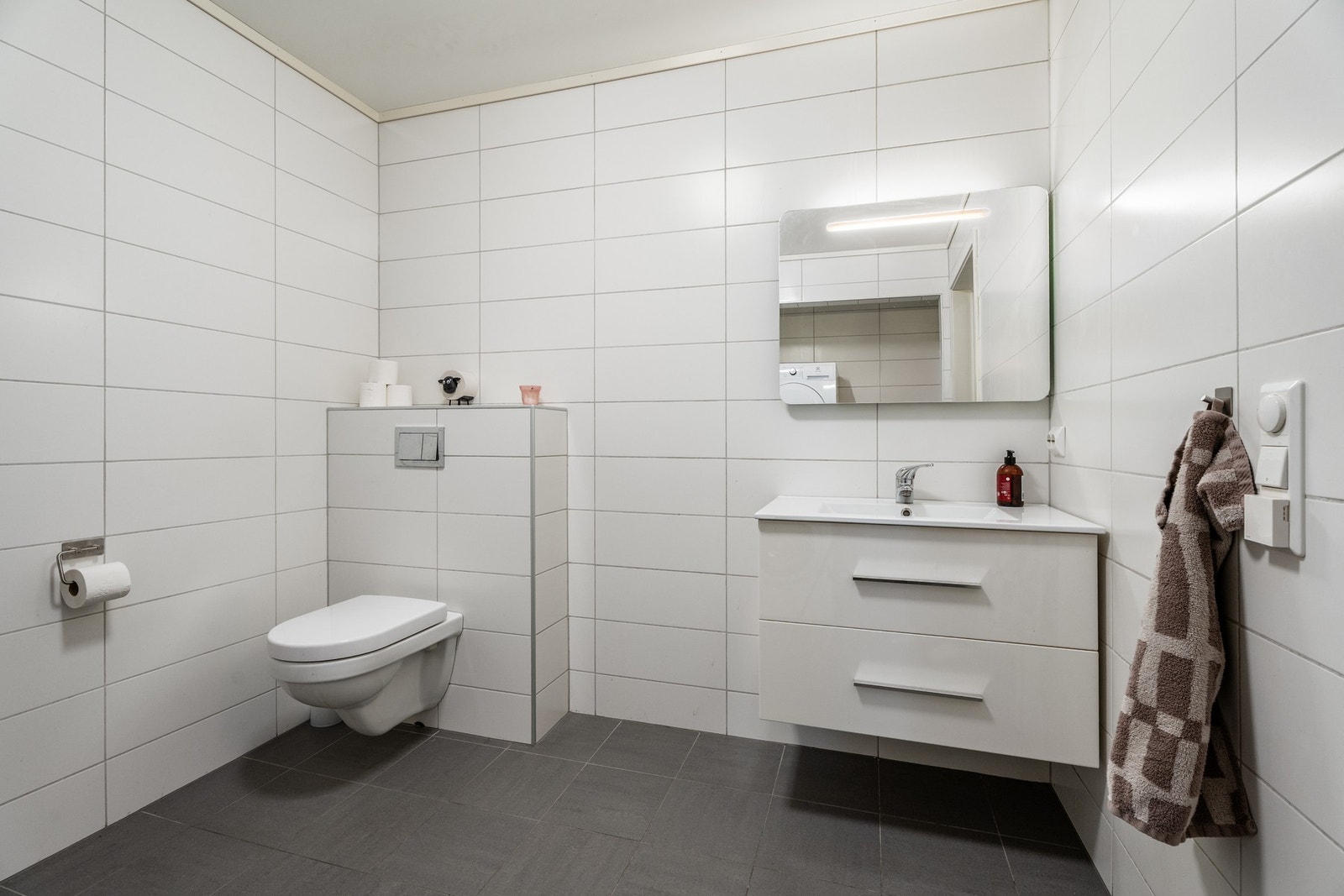 Baderom 1: Lyst og flislagt bad. Leiligheten har totalt to baderom, ett i første etasje og ett i andre. Galleribilde