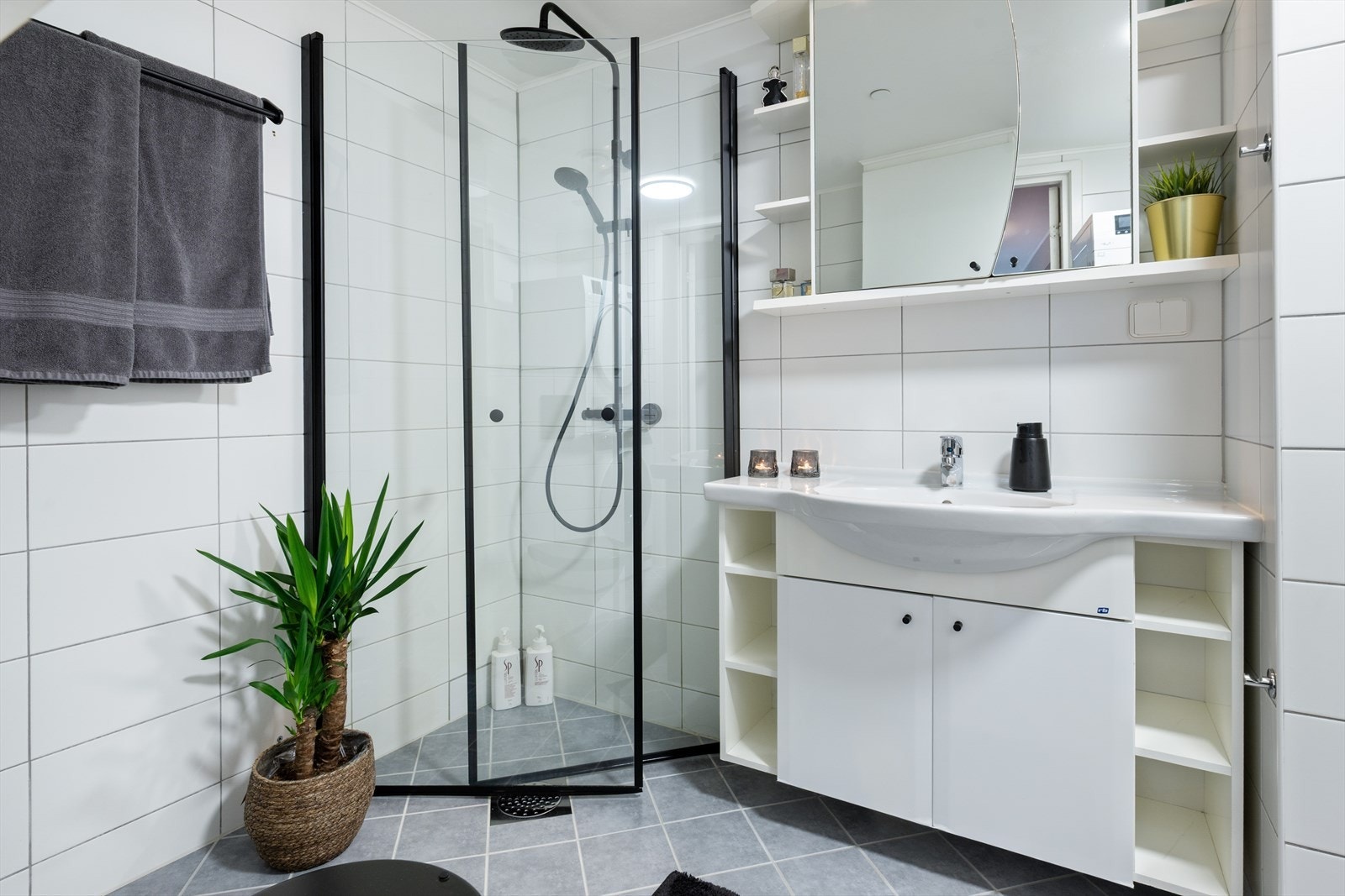 Rommet har innredning med heldekkende servant, veggmontert toalett og speilskap fra byggeår. Innfeltbare dusjvegger/hjørne fra 2025. Opplegg for vaskemaskin Galleribilde