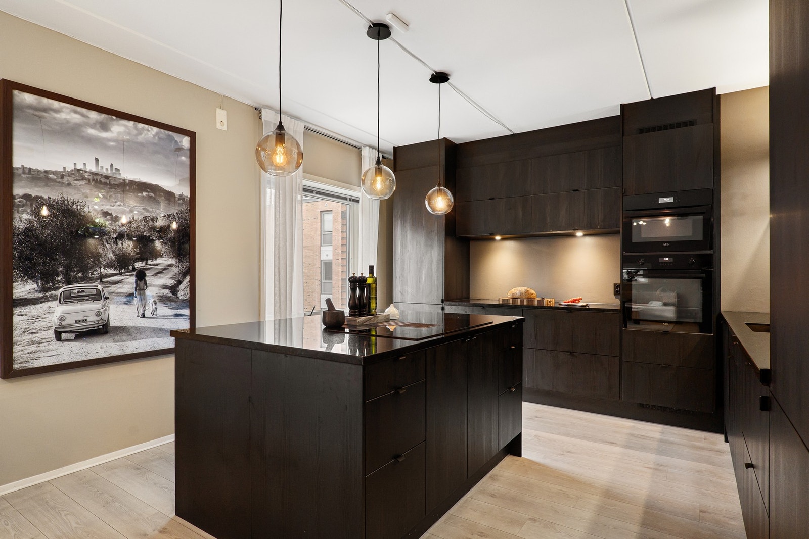 Delikat kjøkken fra Norema i 2021 innredet med glatte, laminerte fronter og benkeplate i polert stein. Galleribilde