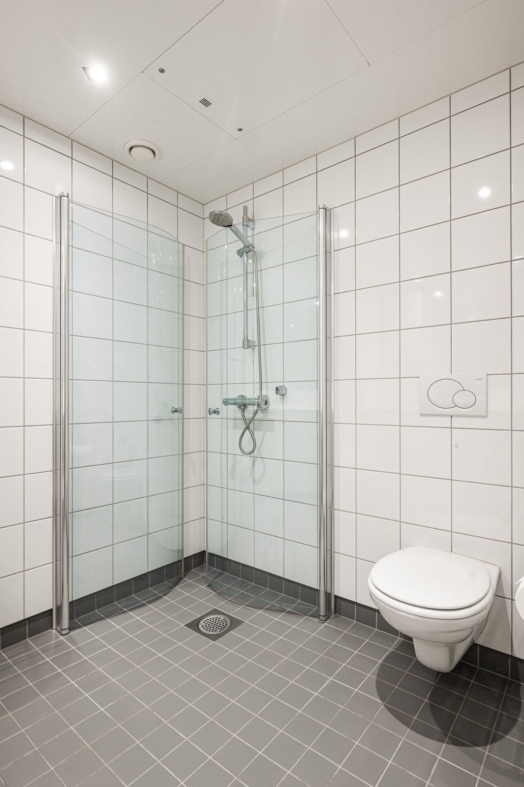 Videre har badet vegghengt klosett og dusjhjørne med innfellbare glassdører. Galleribilde