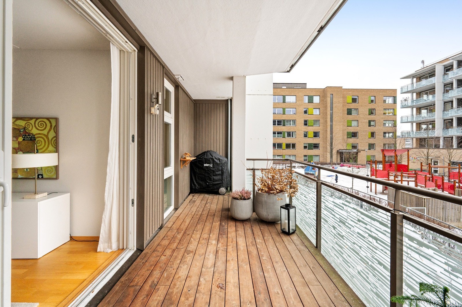 Balkongen er utført i betong med terrassebord i tre og rekkverk i stål med glassfelt. Galleribilde