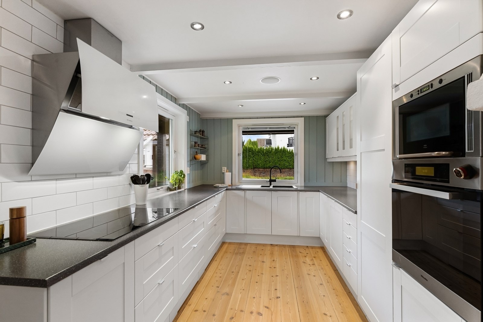 Stort og flott kjøkken med lys innredning. Rikelig med både skap, skuffer og benkeplass Galleribilde