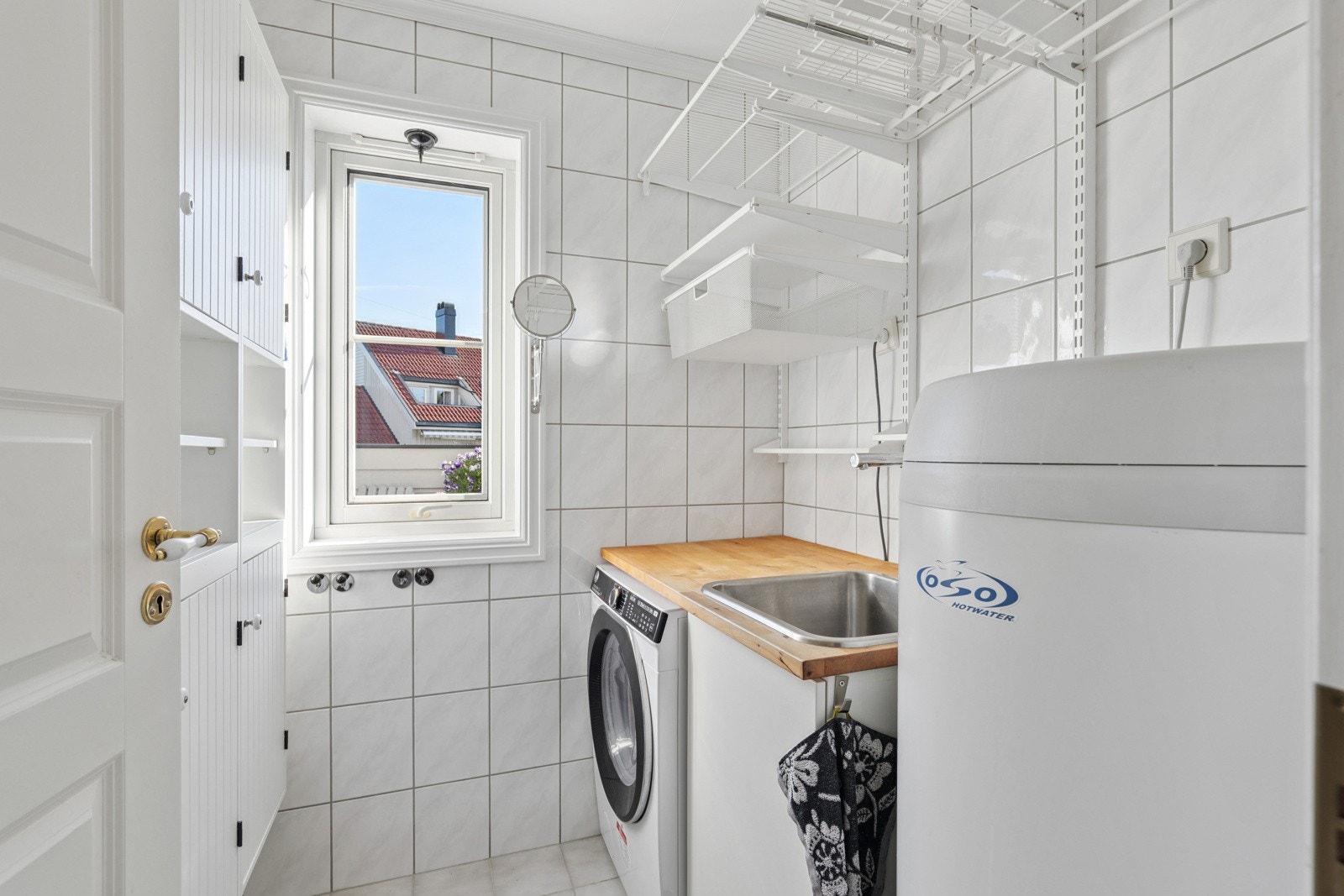 Praktisk og pent vaskerom på innsiden av badet med skap og hyllesystem. Varmekabler i gulv Galleribilde