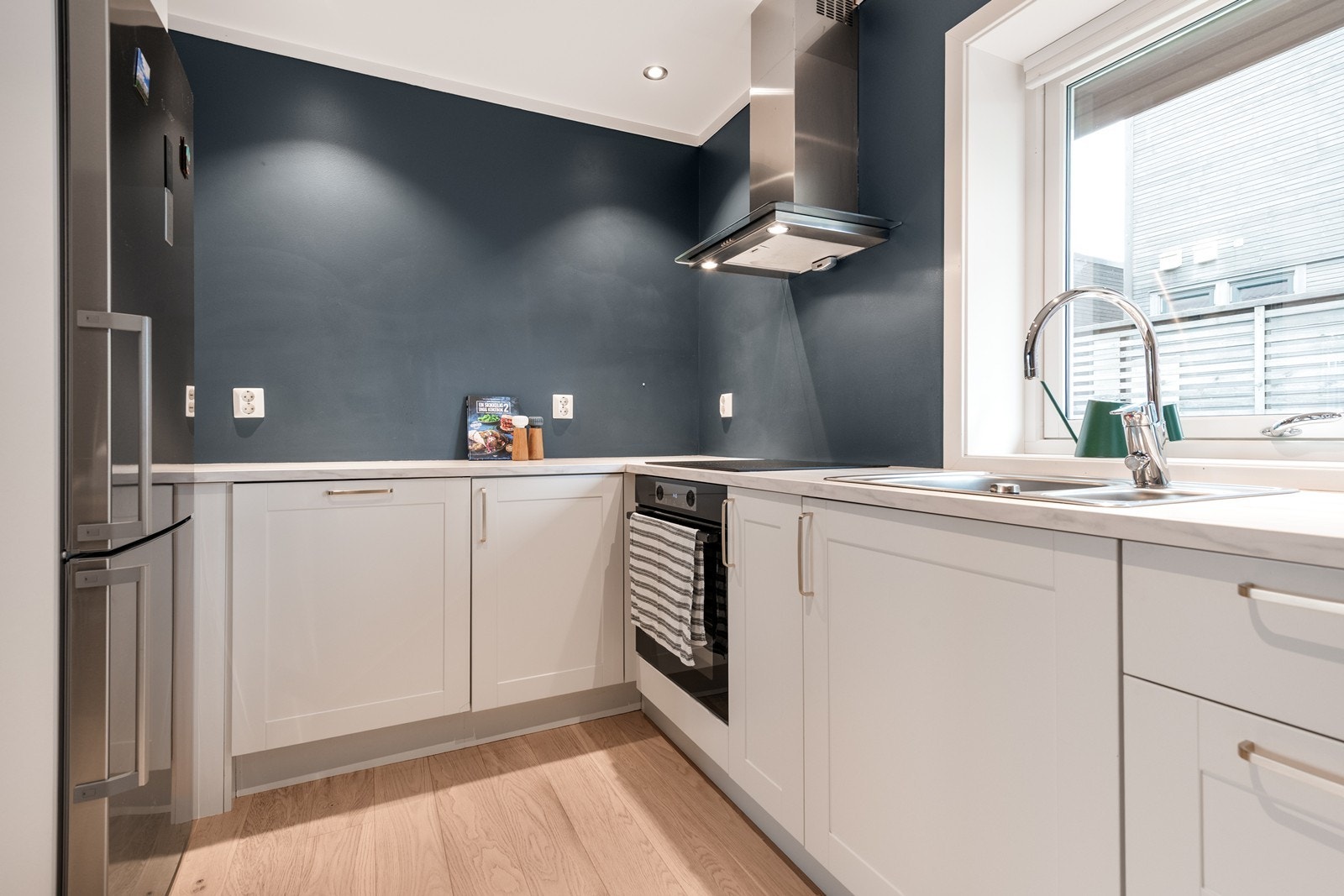 Kjøkkenet har mye benkplass og oppbevaring i skaper langs gulv Galleribilde