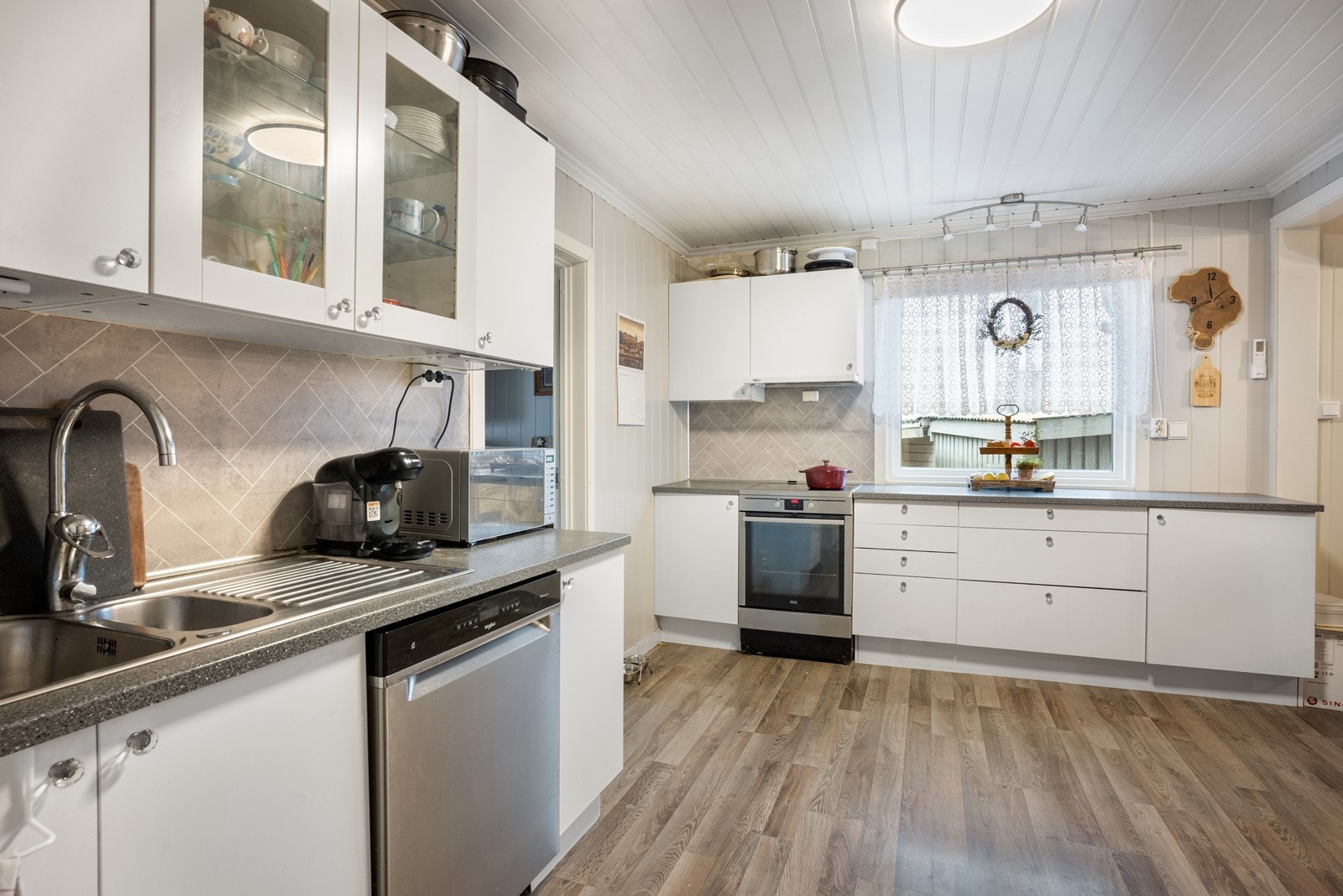 Kjøkken med glatte fronter og laminat benkeplate. Det er godt med skap og skuffer til kjøkkenartikler. Galleribilde