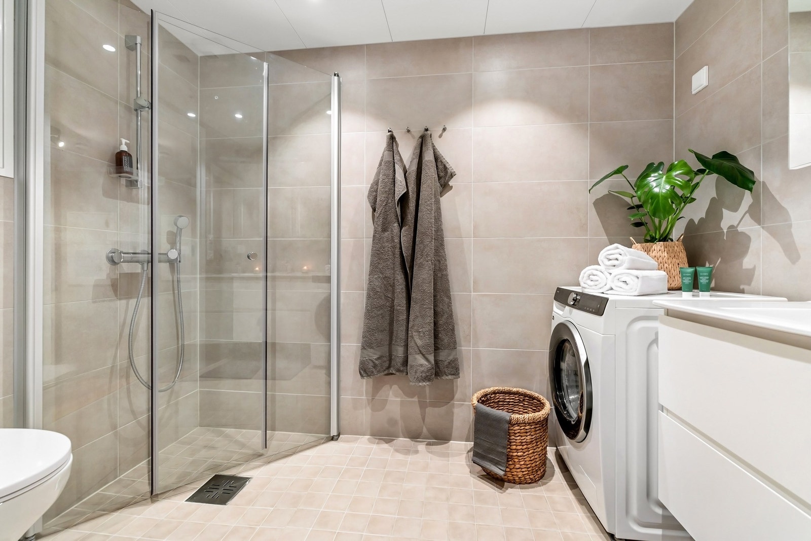 Lekkert flislagt bad med vannbåren gulvvarme og downlights i himling. Galleribilde