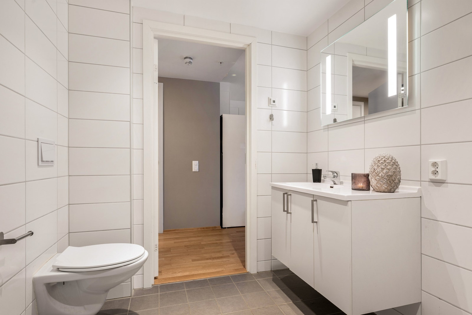 Malt himling med downlights gir et lyst og trivelig uttrykk. Baderommet er innredet med vegghengt servantskap med heldekkende servant og ettgreps armatur. Galleribilde